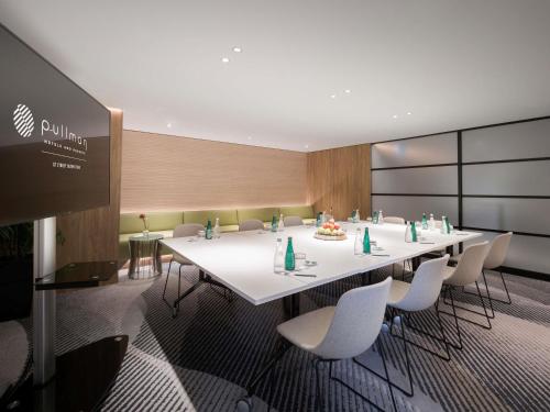 a conference room with a long white table and chairs at Pullman Sydney Olympic Park in Sydney