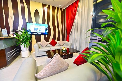 un salon avec un canapé et une table dans l'établissement Ewan Tower Hotel Apartments, à Ajman