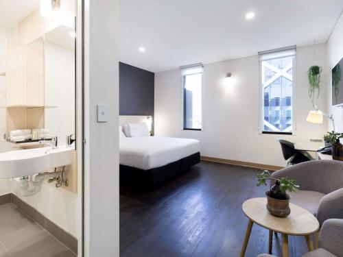a hotel room with a bed and a bathroom at ibis Sydney Barangaroo in Sydney