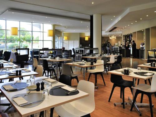 a dining room with tables and chairs and a restaurant at ibis Melbourne - Glen Waverley in Glen Waverley