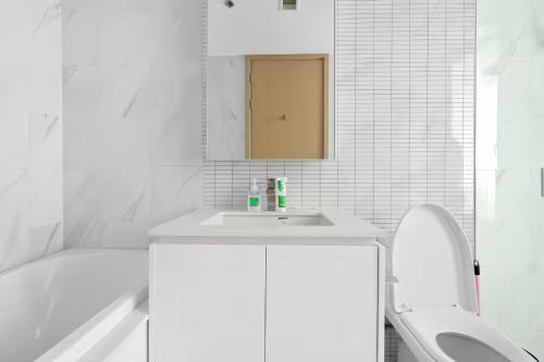 a white bathroom with a sink and a toilet at Hyde Sukhumvit 11 Bangkok in Bangkok