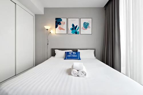 a bedroom with a white bed with two clocks on it at Hyde Sukhumvit 11 Bangkok in Bangkok