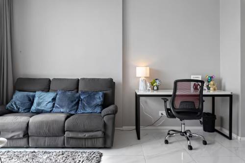 a living room with a couch and a desk and a chair at Hyde Sukhumvit 11 Bangkok in Bangkok