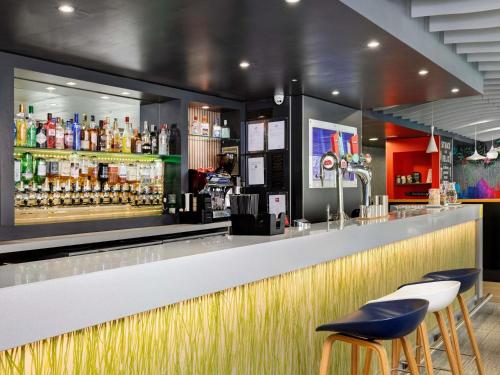 a bar with two stools and a counter with drinks at ibis Brighton City Centre - Station in Brighton & Hove