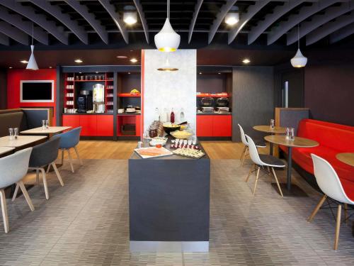 a restaurant with tables and chairs and red cabinets at ibis Brighton City Centre - Station in Brighton & Hove