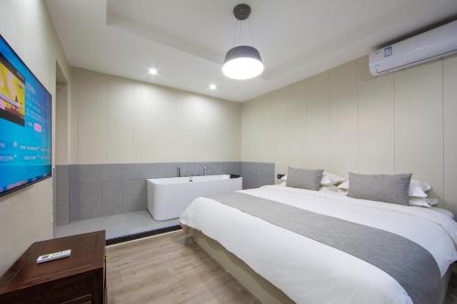 a bedroom with a bed and a bath tub at 铂曼智慧酒店-张家界国家森林公园门票站店 in Zhangjiajie