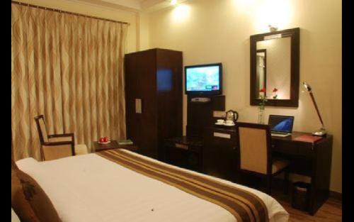 une chambre d'hôtel avec un lit, un bureau et un ordinateur dans l'établissement Royal Residence Cybercity - Gurugram, à Gurgaon