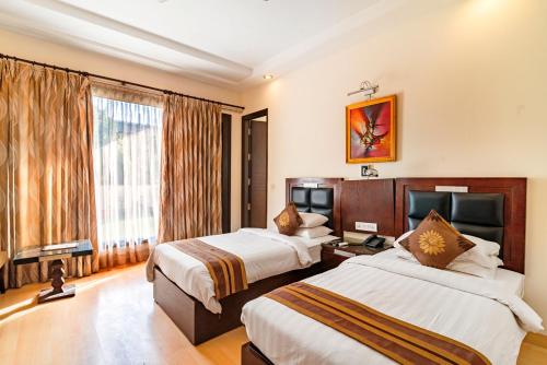 une chambre d'hôtel avec deux lits et une fenêtre dans l'établissement Royal Residence Cybercity - Gurugram, à Gurgaon