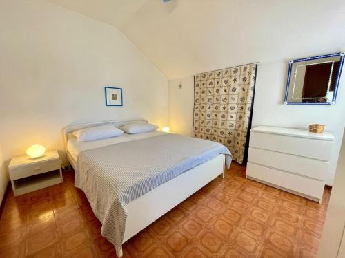 a bedroom with a white bed and a window at Amazing flat with sea view terrace in Porto Santa Margherita di Caorle