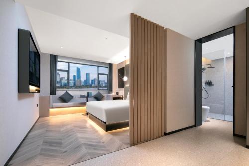 a bedroom with a bed and a living room at Atour S Hotel Ningbo Heyi Avenue in Ningbo