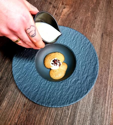 a person is dipping a cookie on a blue plate at Mintrops Stadt Hotel Margarethenhöhe in Essen