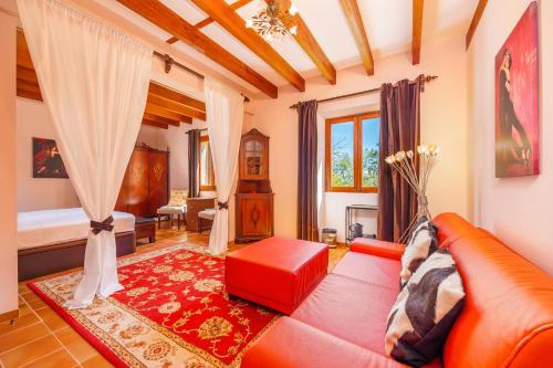 a living room with a red couch and a bedroom at Es Pouet in Binissalem
