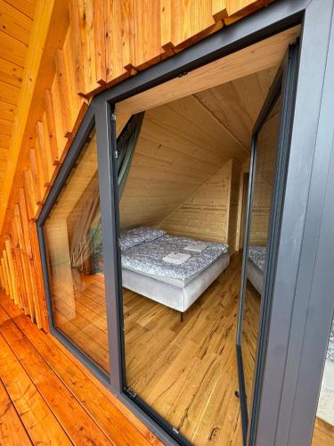 a room with a bed inside of a wooden house at Świerkowe Chatki w Koniakowie in Koniaków