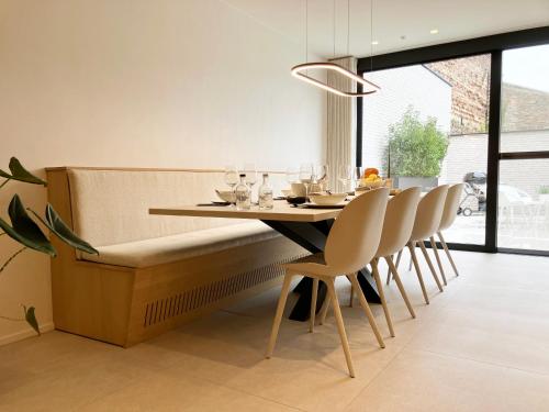 a dining room with a bench and a table and chairs at Het Huisje in Tongeren