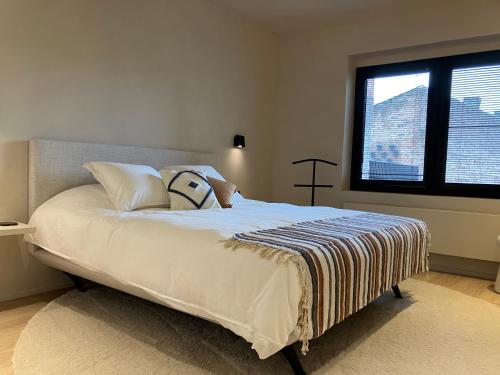 a bed in a bedroom with a large window at Het Huisje in Tongeren