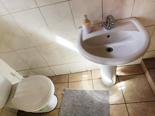 a bathroom with a sink and a toilet at Tokelo Guesthouse Emalahleni in Witbank