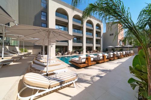 a pool with chaise lounge chairs and an umbrella at Alizo Comfort Chic Stay Rhodes - Adults Only in Ixia