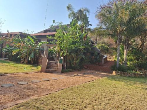 a house with palm trees in front of it at Mount Festiva Lodge in Akasia