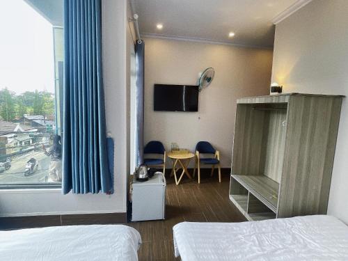a hotel room with a bed and a window at NA NI in Da Lat