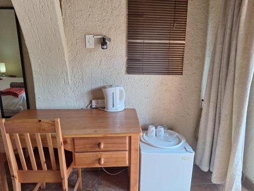 a wooden desk with a chair and a washing machine at Mount Festiva Lodge in Akasia