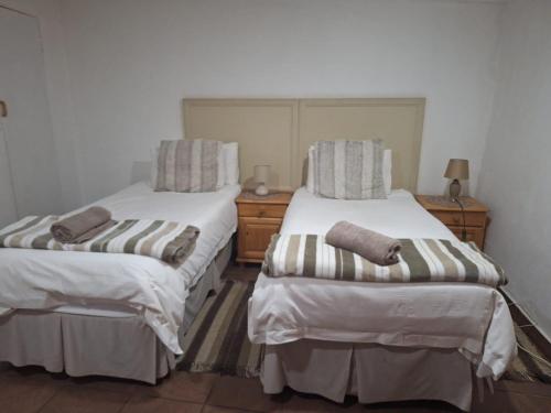 two beds sitting next to each other in a room at Mount Festiva Lodge in Akasia