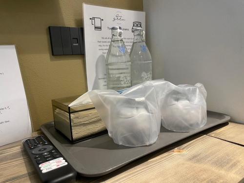 a tray with two bottles of water and a remote control at Airport one station hometel - Suvarnabhumi - SHA Extra Plus in Bangkok