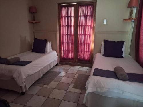 a room with two beds and a window at Mount Festiva Lodge in Akasia