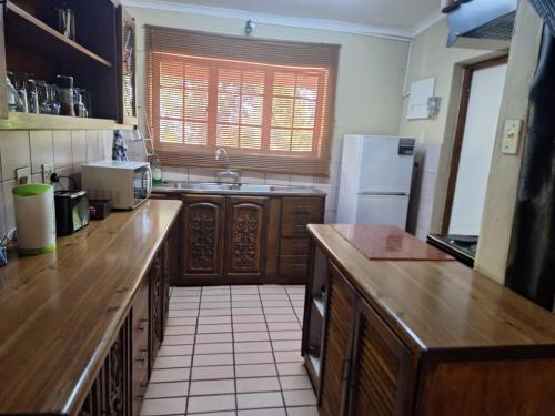 a kitchen with wooden counter tops and a refrigerator at Mount Festiva Lodge in Akasia