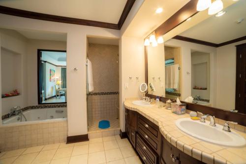 a bathroom with two sinks and a bath tub and a tubermott at Vista Bahia 3C 3 bdr Ocean View in Los Suenos in Herradura