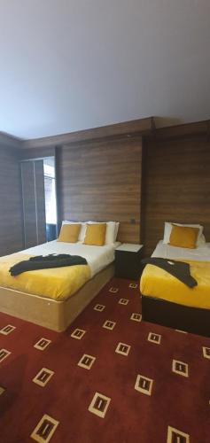 two beds in a room with a carpet at South Beach Kings Promenade Hotel in Blackpool
