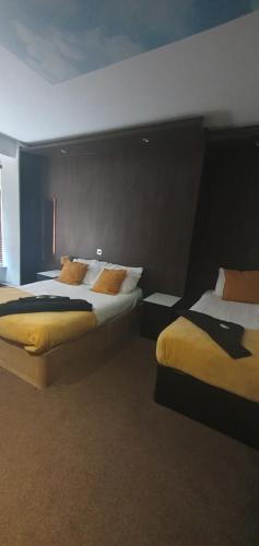 a hotel room with two beds with yellow pillows at South Beach Kings Promenade Hotel in Blackpool