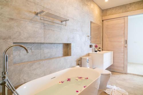 y baño con bañera y aseo. en Sea View 2-Bed Apt Walk to Beach - KBR35, en Ban Bang Po