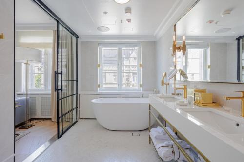 a white bathroom with a tub and a sink at The Hotel Maria Helsinki in Helsinki
