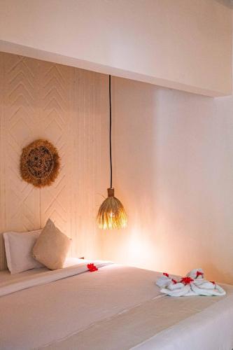 a bedroom with a white bed with a chandelier at Seconda Stella Romantic Hideaway in Jambiani