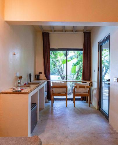 a kitchen with a large window and a table and chairs at Seconda Stella Romantic Hideaway in Jambiani