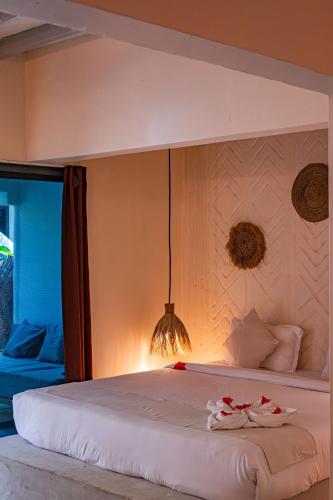 a bedroom with a large bed with towels on it at Seconda Stella Romantic Hideaway in Jambiani