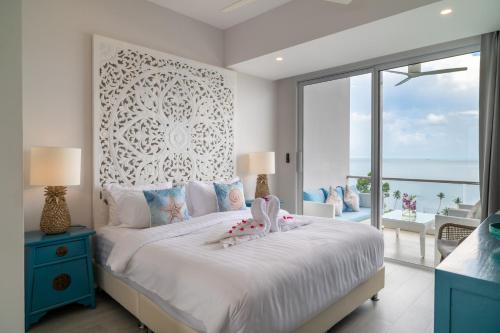 Un dormitorio con una cama grande con vista al mar. en Top Floor 2 Bed Sea View Apartment - KBR38, en Ban Bang Po
