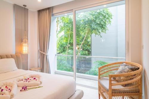 Un dormitorio con una cama y una ventana grande. en Cozy 2-Bed Apt by the Sea Beach - KBR37, en Ban Bang Po