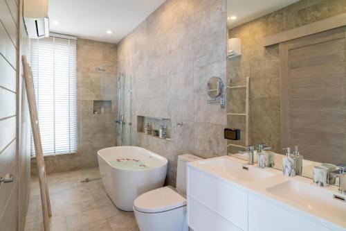 Un baño con lavabo, inodoro y bañera. en Cozy 2-Bed Apt by the Sea Beach - KBR37, en Ban Bang Po