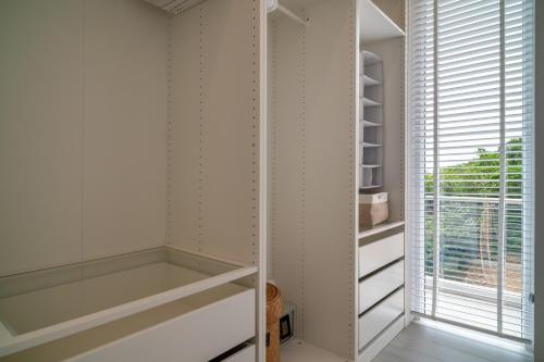 Un vestidor con gabinetes blancos y una ventana. en Top Floor 2 Bed Sea View Apartment - KBR38, en Ban Bang Po