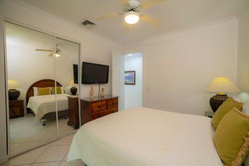 a bedroom with a bed and a mirror and a television at Colina 5D 3 bdr Garden View in Los Suenos in Herradura
