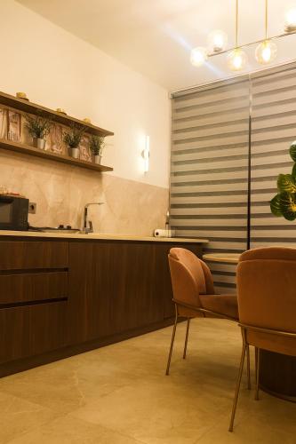a kitchen with a sink and a table and chairs at Elegant Ephesus Suites - Artemis in Selçuk