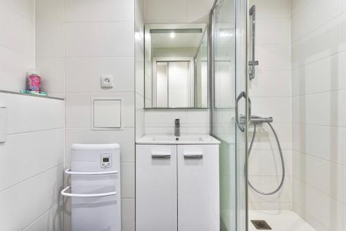 Un baño blanco con lavabo y ducha. en Résidence à Cannes, en Cannes