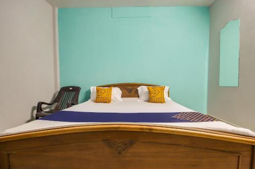 a bedroom with a bed with a wooden bed frame at SPOT ON Raahila Mansion in Kumbakonam