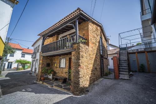 a brick building with a balcony on the side of it at Villa Casas de São Francisco da Chã in Góis