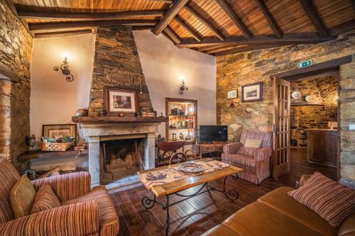 a living room filled with furniture and a fireplace at Villa Casas de São Francisco da Chã in Góis
