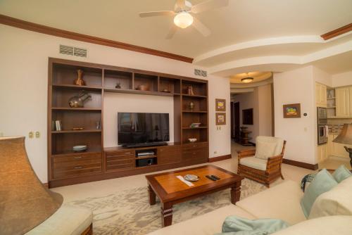 a living room with a couch and a tv at Bella Vista 2D 3 bdrs pool view in Los Suenos in Herradura