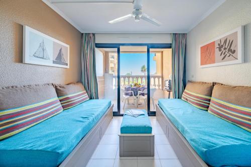Una sala de estar con un sofá y un balcón. en Résidence à Cannes, en Cannes
