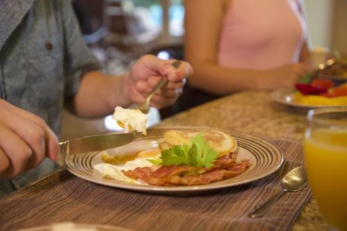 a person eating a plate of food on a table at Veranda 3B 2 bdr Garden View in Los Suenos in Herradura