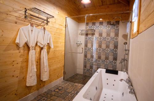 a bathroom with a shower and a sink and a tub at La Cabana Beach & Spa, By Ashvem Beach in Mandrem
